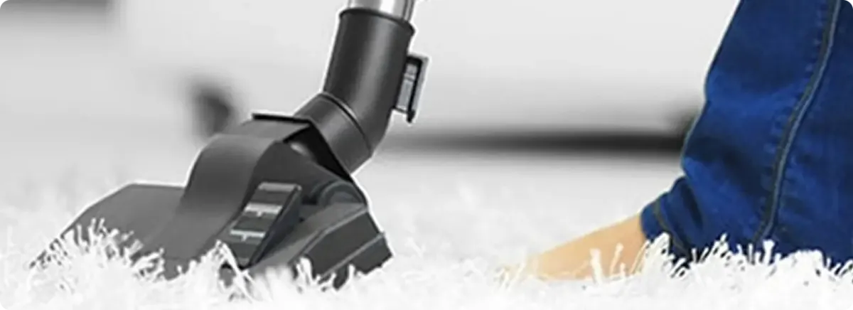 Close-up of a professional vacuuming a white carpet in Osprey.